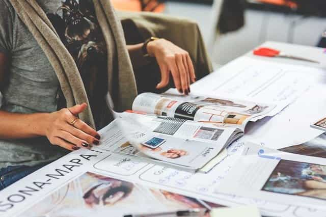 A woman looking at newspapers. 