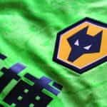 A green football shirt with a Wolverhampton Wanderers logo on it.