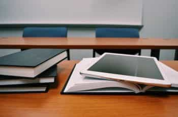 Books and an iPad on a school desk.