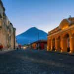 Old fashioned buildings with a mountain in the background in Bulevar Villa Deportiva, Guatemala.