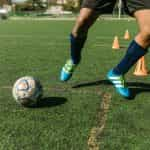 A footballer training on a grass pitch.