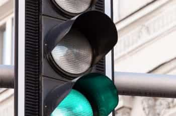 A traffic light in the street showing a green light.