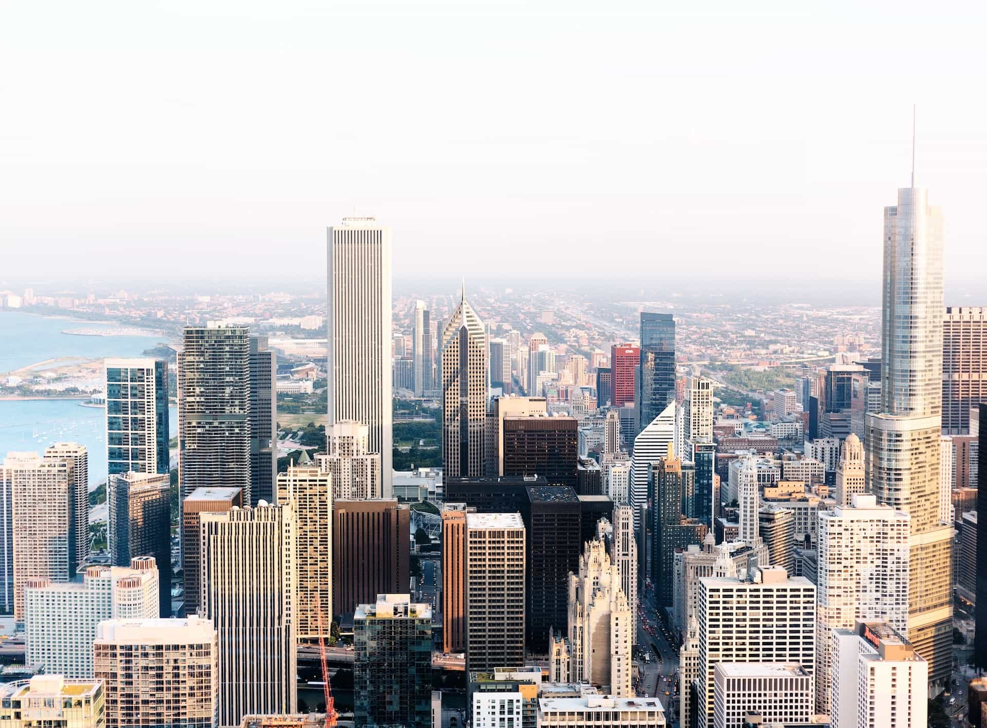 The skyline of downtown Chicago in the US midwestern state of Illinois, featuring a dense district of tall buildings and skyscrapers, flanked by one of the Great Lakes to the left.