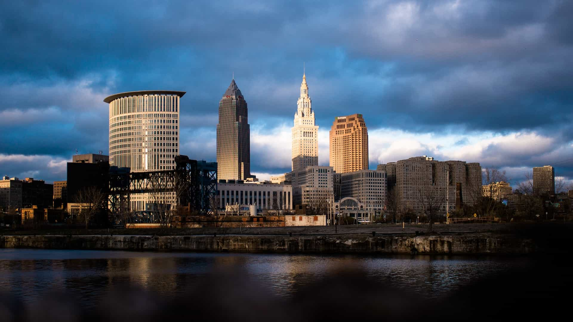 The skyline of downtown Cleveland in the midwestern state of Ohio, featuring several tall buildings and skyscrapers against an ominous and cloudy sky.