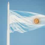 The Argentina flag flies against a blue sky.